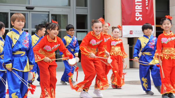 30名不同膚色的小學生穿著傳統的中華服裝跳舞；