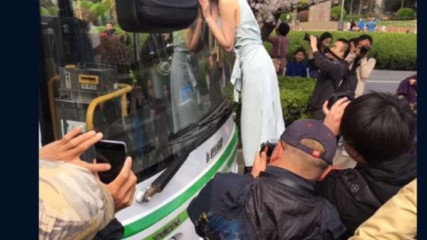 大陸春天花季登場，繼櫻花樹上爬滿大媽之後，有「上海最美公車站」美譽的南浦大橋浦西公交樞紐，也出現了把公車當成道具車、姑娘貼車等離譜行為。