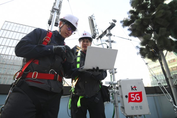 2019年4月4日，韓國電信運營商KT的技術人員在首爾一座大樓的屋頂上檢查5G移動網路服務天線。