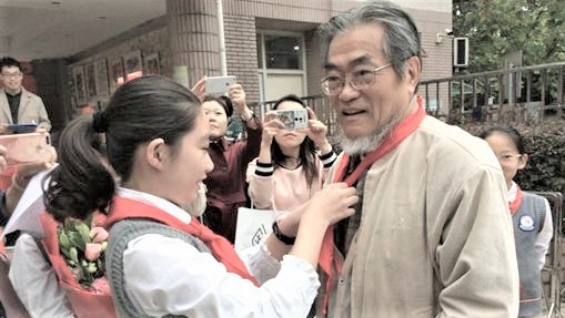 邵子平（右）在南京接受中国共产党少先队成员配戴红领巾