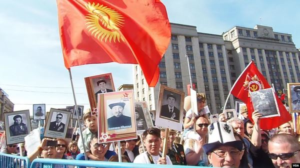 2015年5月9日莫斯科红场附近的不朽军团游行中，在莫斯科的一些吉尔吉斯人手举国旗参加了活动。（美国之音白桦拍摄）