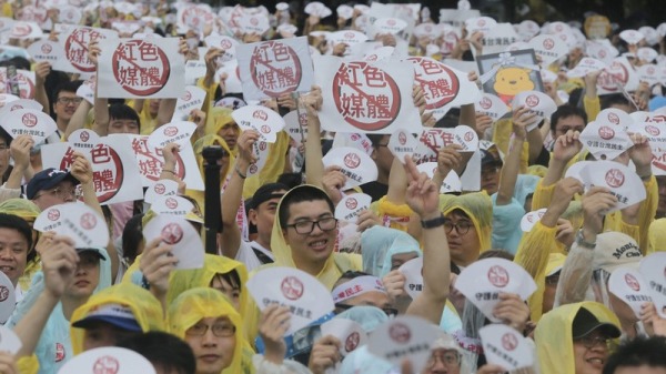 “拒绝红色媒体、守护台湾民主”活动23日下午在总统府前凯达格兰大道登场，参与民众高举反亲中媒体的自创标语，表达诉求。