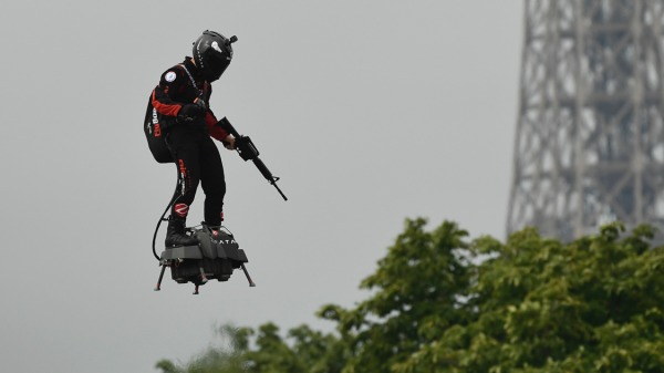2019年7月14日，法蘭奇.薩巴塔( Franky Zapata)在埃菲爾鐵塔附近腳踏飛行滑板，手上拿著現代步槍，快速在香榭裡舍大道飛掠