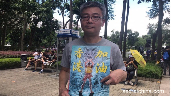 拿着看中国海报的李先生直言港人不喜欢中共才移居香港。（图片来源：周秀文／看中国摄影）