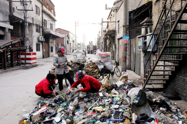 Workers sort garbage on the street in front of their workshop on February 1, 2007 at Lianjiao, Foshan city, Guangdong province of China. (Photo by Cancan Chu/Getty Images)