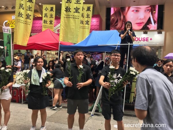 7月1日，香港學生在銅鑼灣向示威民眾派送白花。