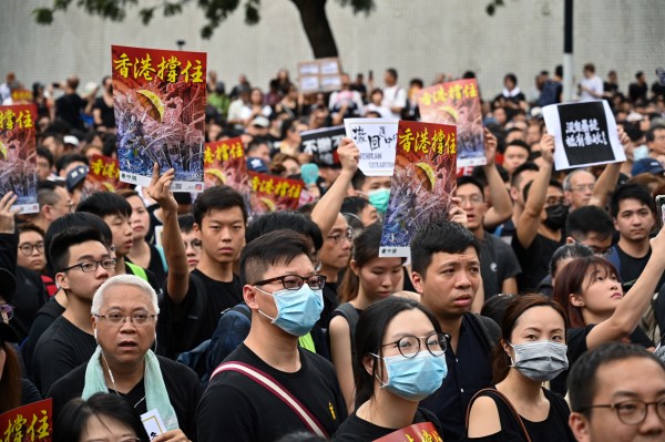 7月7日，23万香港人参加了九龙“反送中”游行，游行人士手持《看中国》印刷的“香港撑住”画报。