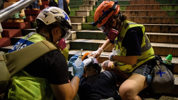 志愿者救援人员为遭受警方催泪弹袭击的受害者治疗。