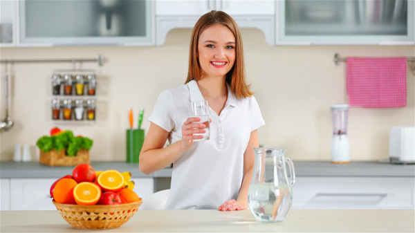 一個女人在廚房喝水