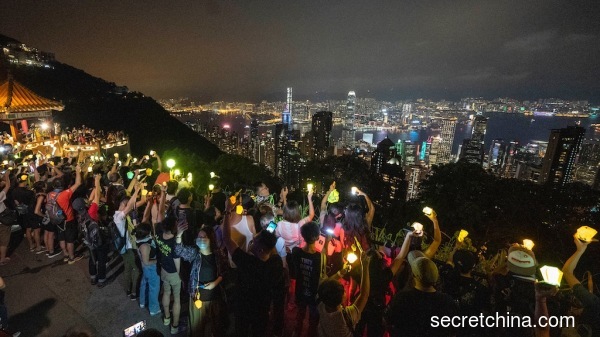 中秋节在港岛区的太平山顶亮起灯光，高唱《愿荣光归香港》歌曲响彻云霄。