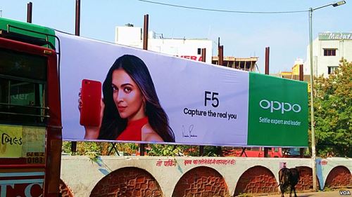 印度乌代普尔，一条神牛经过OPPO新款手机广告。