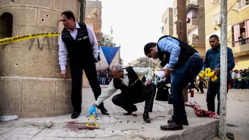 2017年12月29日，埃及安全部队成员和法医警察在首都开罗南部的一座教堂外检查枪击事件。