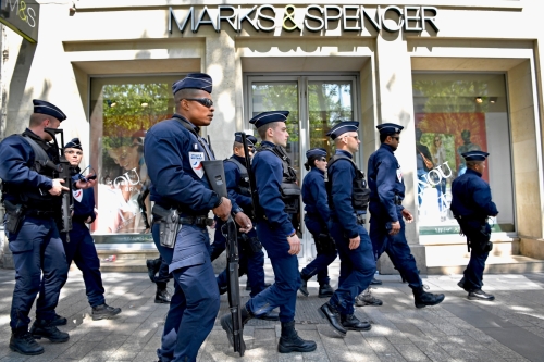 2017年4月21日，由於一名巴黎警察昨天在法國巴黎「香榭麗舍大街」上被槍殺，一群法國武裝警察走過發生該槍擊事件的Marks＆Spencer商店。（圖片來源：Getty Images）
