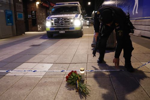 一名警察在事故现场向死者献花表示哀悼