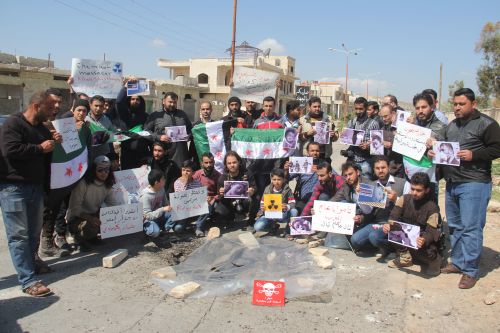 叙利亚居民举牌反对政府军对平民使用化学武器 