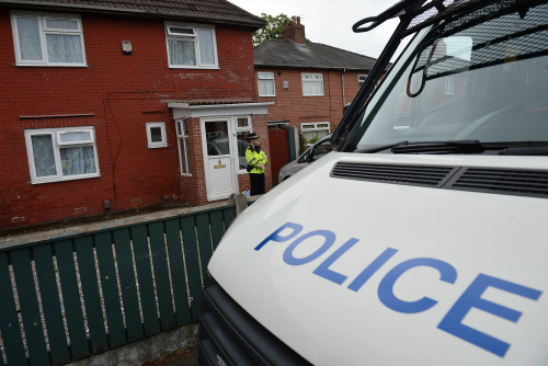 5月24日，一名警察在曼彻斯特的Fallowfield阿斯顿大街一个住宅前值班。