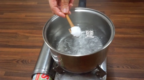 3、取一空锅，放入清水，沸腾后，放入一汤匙的油，再放一茶匙的盐。