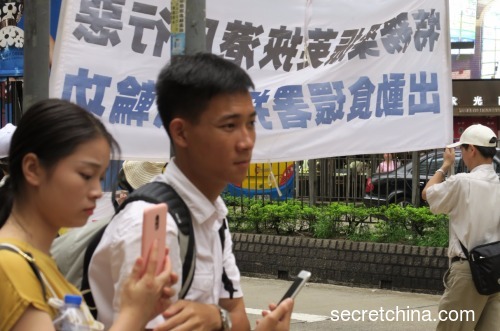 香港市民看到指控活摘器官展版后神色凝重。