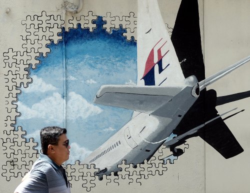 一名马来西亚男子在MH370的壁画前走过
