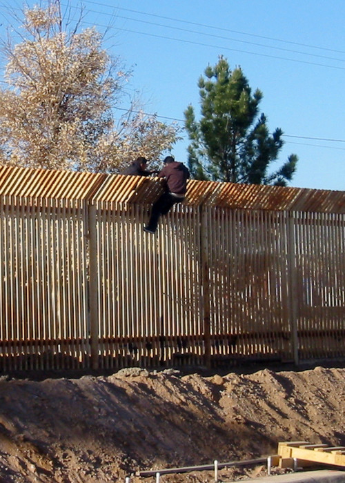 2009年3月，两名男子在美国亚利桑那州道格拉斯附近翻越围栏折返墨西哥。