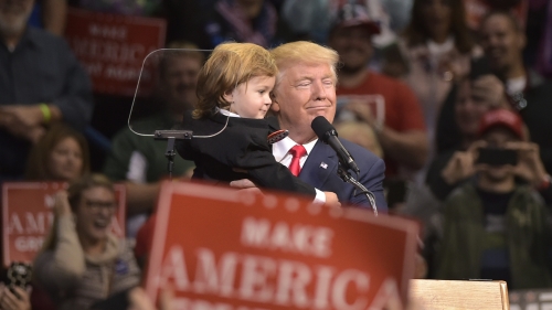 2016年川普在宾州集会抱起一名装扮成他的样子的小支持者。
