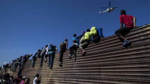 来自中美洲的大篷车难民在墨西哥蒂华纳试图突破围栏
