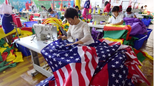 2018年7月13日，安徽省東部阜陽的一家工廠的工人們正在縫製美國國旗。