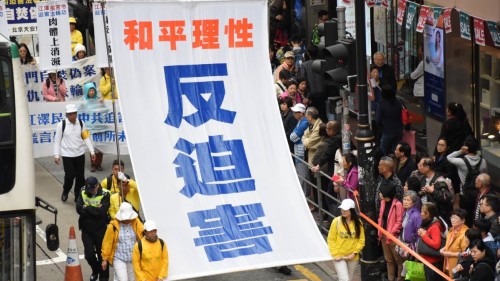 香港法輪功團體舉行大遊行，民眾駐足觀望