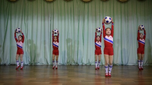 在朝鮮邊境的新義州市幼兒園孩童們，拿著足球配合著音樂跳舞玩足球