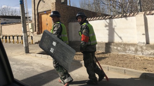 當地警方正在中國西部新疆地區和田縣的一個村莊巡邏（圖片來源：BEN DOOLEY / AFP / Getty Images）