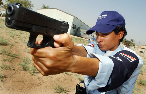2004年7月18日，伊拉克巴格达一名女警察手持格洛克9毫米手枪瞄准目标。