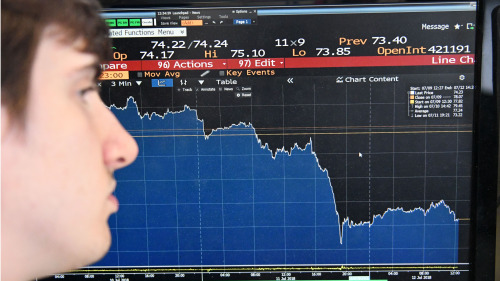 一名記者正緊盯著彭博社的國際原油價格走勢圖（圖片來源：Getty Images）