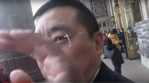 全国人大代表魏树旺被采访时，伸手挡住记者摄像机
