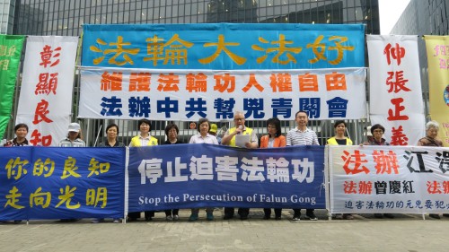 香港法轮功团体26日在香港政府总部前集会，呼吁香港政府依法究办青关会。