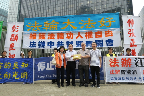 集会后，港府（前左二）代表接过香港法轮功团体的请愿信