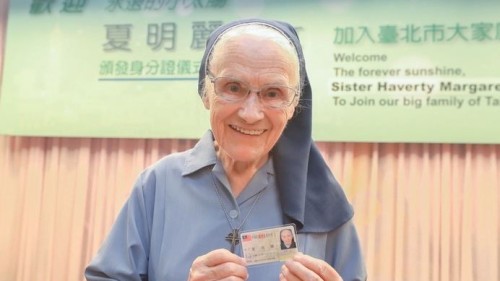 台北市政府27日在台北舉行修女夏明麗（圖）頒發身分證儀式，拿到身分證後，她開心合影留念。