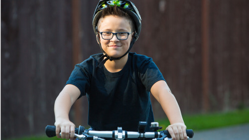 男孩以五塊錢在拍賣會中買來的漂亮腳踏車，臉上流露出燦爛的笑容。