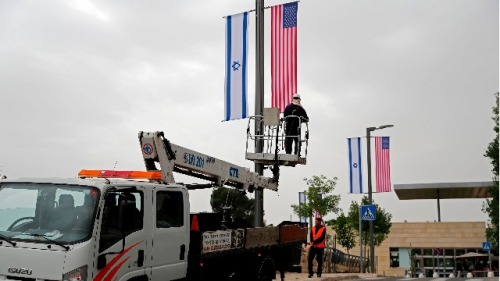 2018年5月7日，一名工人在美国驻耶路撒冷大使馆前安装以色列和美国国旗的装饰品。