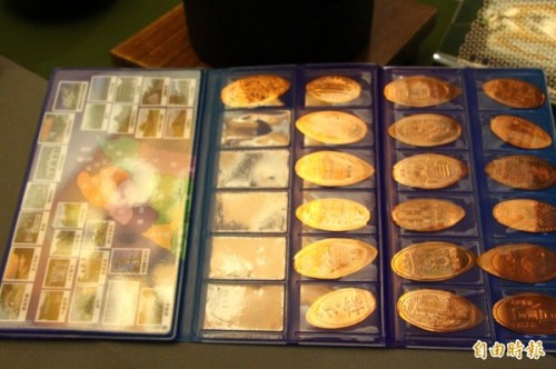 萩原骏介用收集本收集台湾各地景点的纪念币。