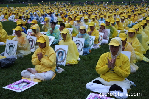 来自世界各地数千名法轮功学员在雨中准备举行烛光夜悼活动