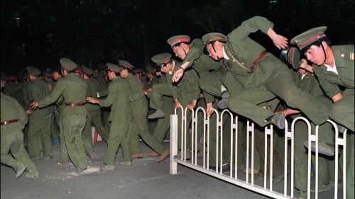 1989年6月，中共士兵在天安门广场跨越障碍物。（图片来源：CATHERINE HENRIETTE/AGENCE FRANCE-PRESSE — GETTY IMAGES）