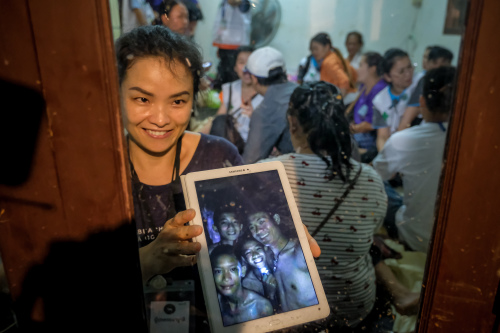 泰国失踪男孩的亲属显示他们被困洞内的照片。