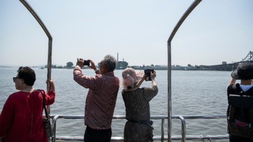 2018年5月31日，一些中国游客在辽宁省丹东的鸭绿江上拍照。