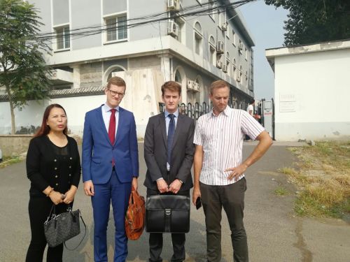 孙茜妹妹孙赞（左一）与外媒记者、两外国使节在温榆河法庭前合影留念。