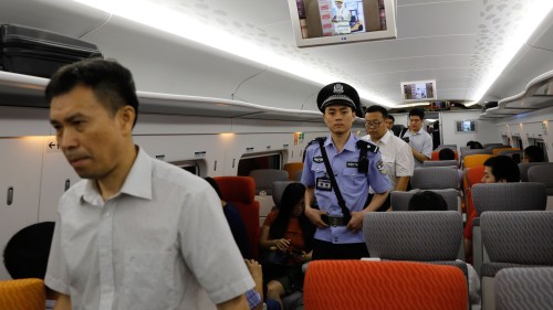 停在香港西九龙站的高铁列车内，有身穿浅蓝色制服的内地人员巡逻