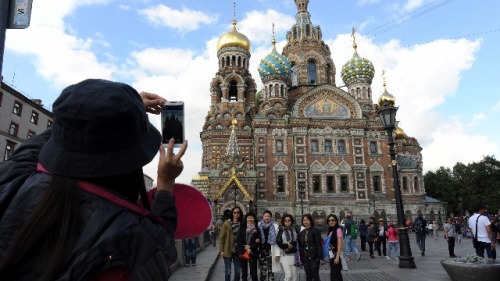 中国游客在圣彼得堡的一处教堂前拍照留念。