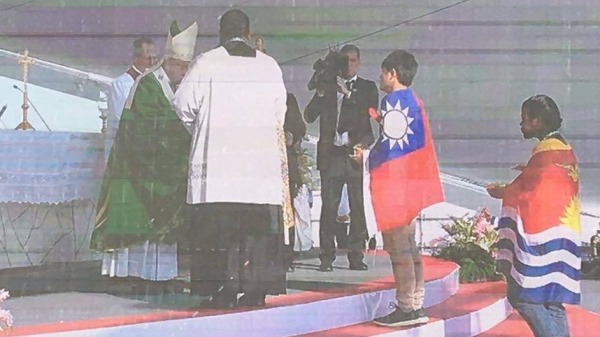 台灣青年身披青天白似滿地紅國旗，代表亞洲青年上台向教宗奉獻酒水。