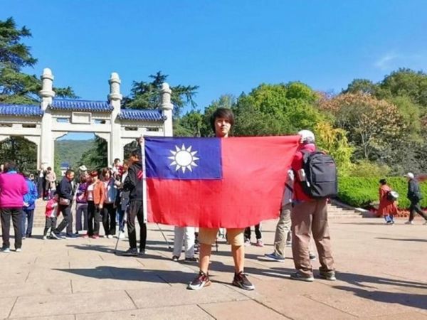 楊翰傑於南京中山陵舉起中華民國國旗拍照