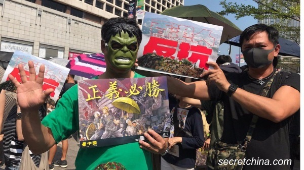 有港人戴著《復仇者聯盟》電影中「綠巨人浩克」的面具，手持《看中國》最新的海報「正義必勝」。（圖片來源：周秀文／看中國攝影）