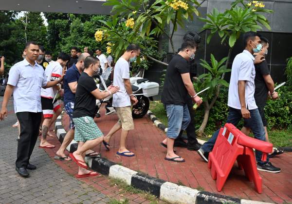 2019年11月26日在雅加达举行的新闻发布会后，印尼警方护送一群涉嫌诈骗的中国和印尼犯罪嫌疑人。